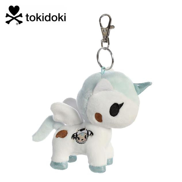 A keychain featuring a plush winged unicorn in white, with a light blue horn, and a cow design on the side.