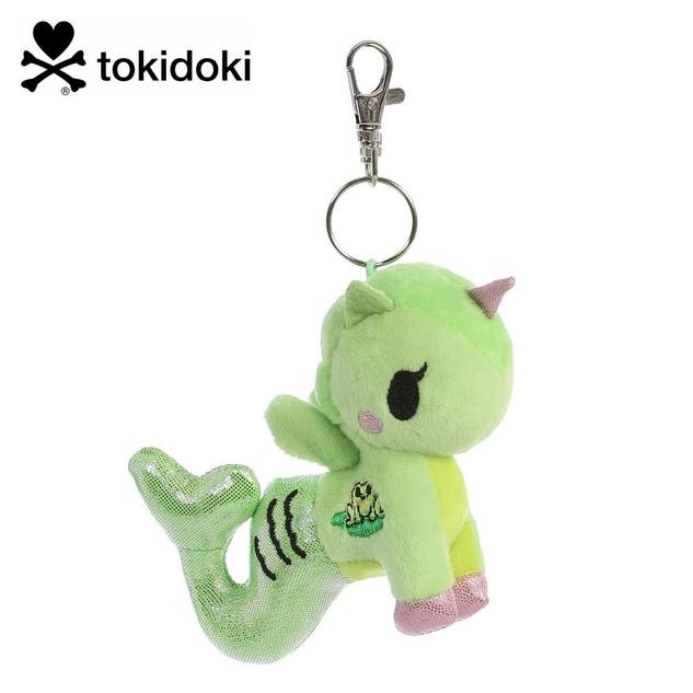 A keychain featuring a plush mermicorn in green, with a pink horn, and a frog design on the side.