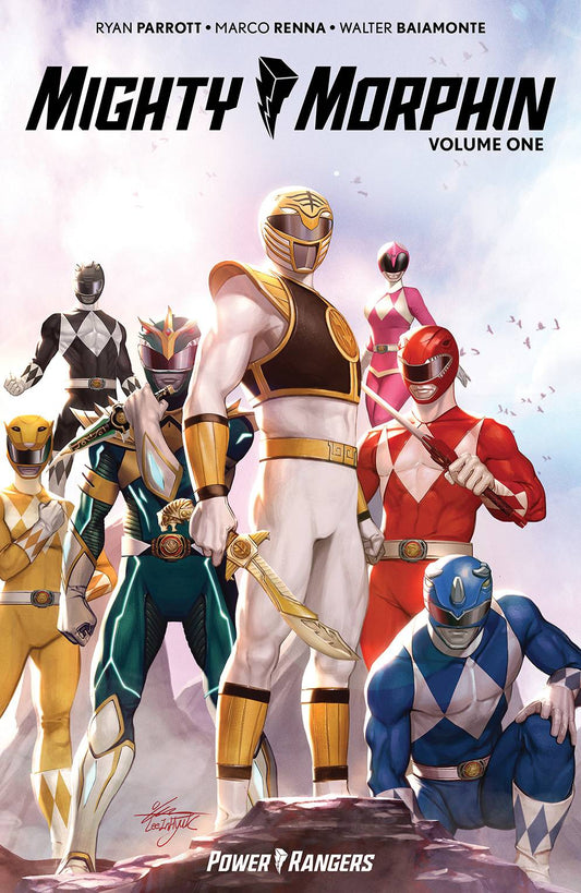 The Power Rangers stand atop a rock - white in front, holdng a sword; blue crouching beside them; red behind holding a sword; green to the left clutching a dagger; yellow behind with their hand clenched over their chest; and black and pink at the back, standing the highest with their arms out to the sides, ready.